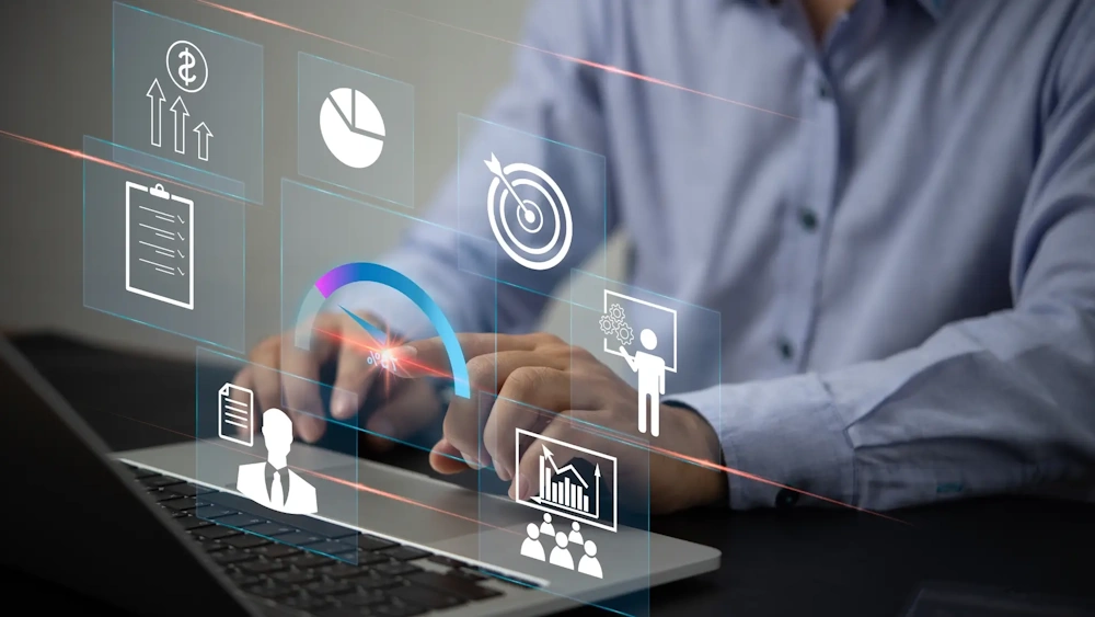 A social media manager typing on a laptop with digital interface icons