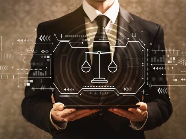 Person in a suit holding a tablet with a holographic justice scale icon representing digital marketing for lawyers